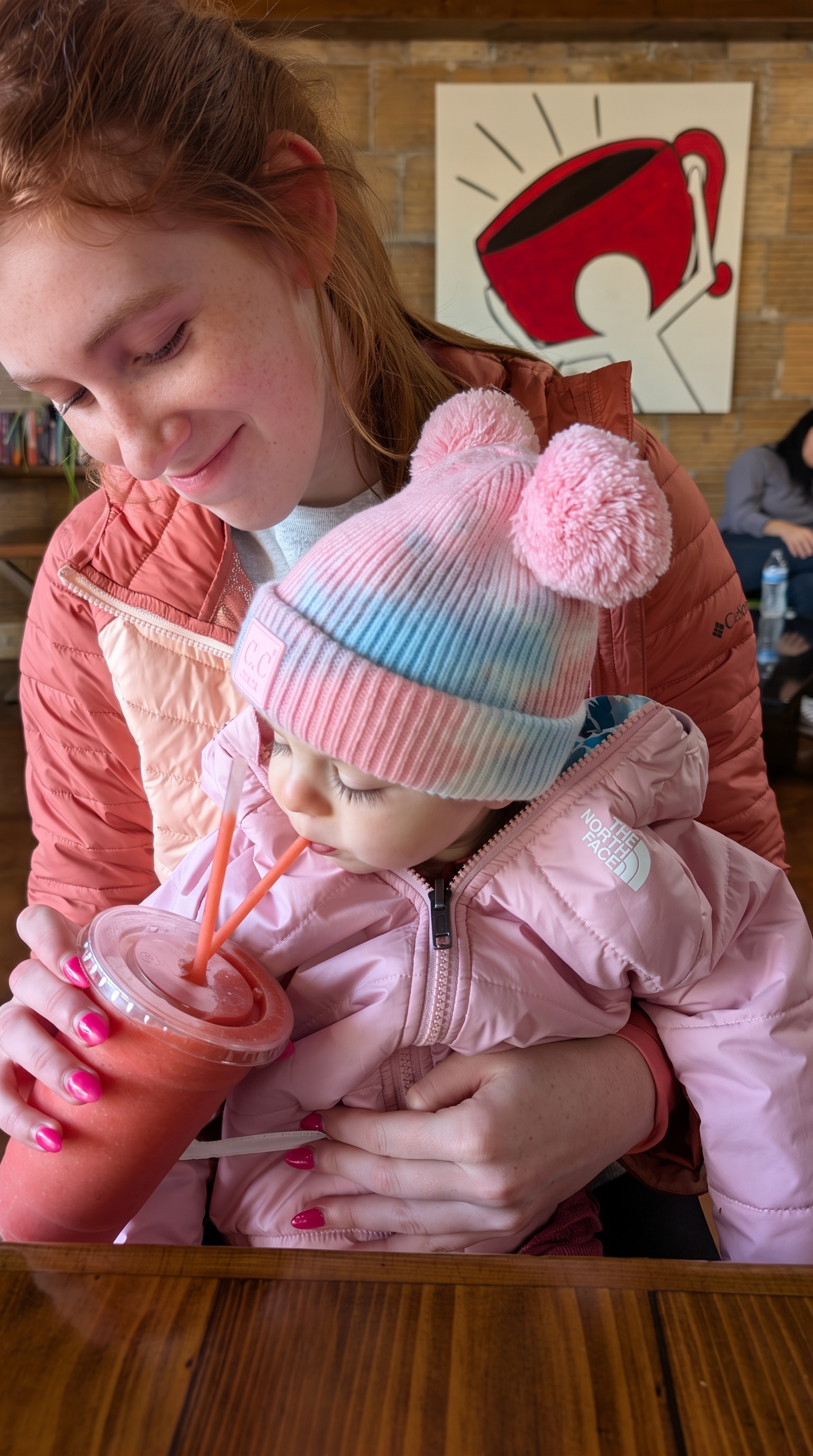 Elizabeth sharing smoothie with toddler